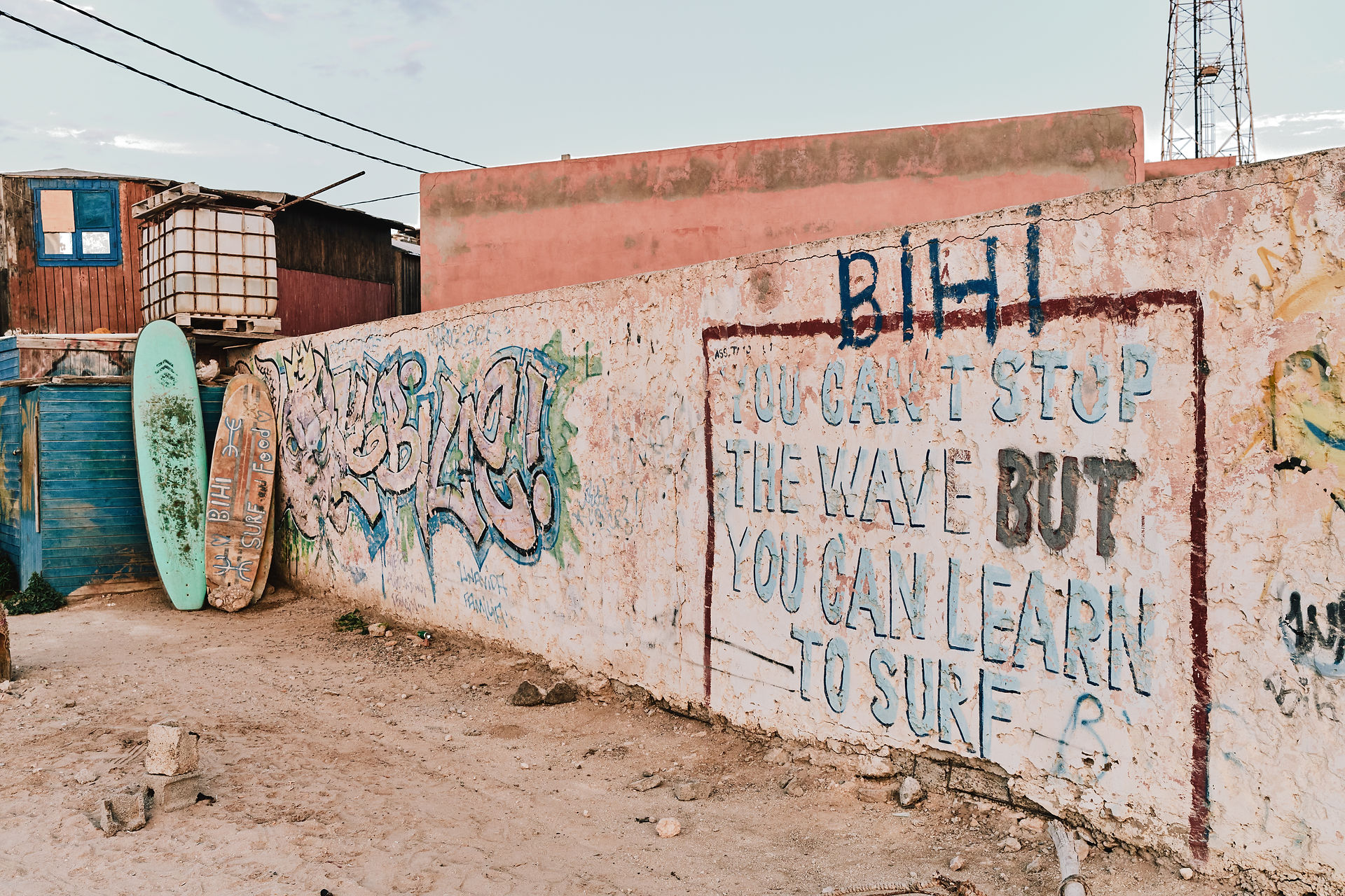 Graffiti na stěně s nápisem You can't stop the wave but you can learn to surf