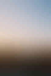 Muž sedí na hradbách s opřenými nohami o kanón