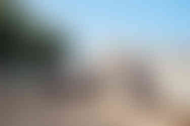 Muž opírající se o stěnu s telefonem v ruce