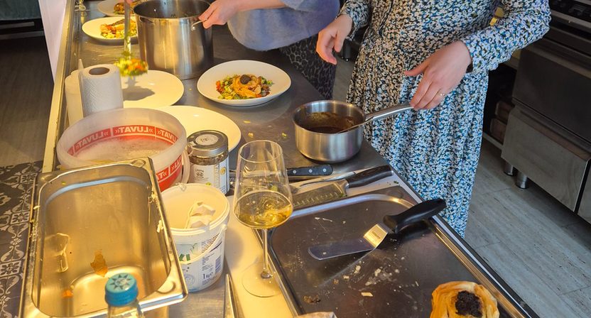Zwei Köche bereiten Essen vor, mit Töpfen, Pfannen und Tellern Franzhomekitchen.