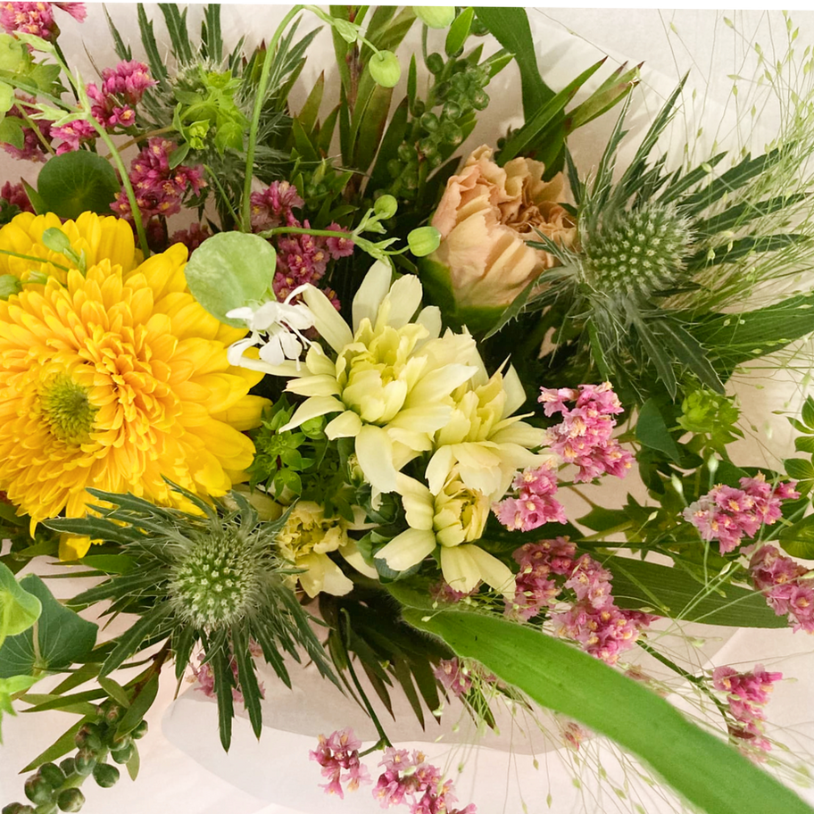花束Sサイズのフラワーブーケ。黄色と白を中心にした季節の花を柔らかい色合いで仕上げたアレンジ。