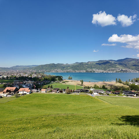 Scenic lakeside town view with green hills and mountains