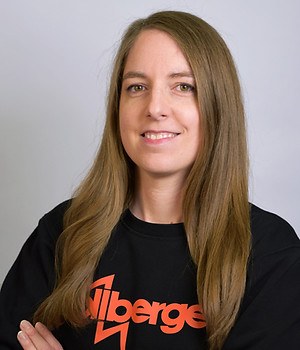 Lächelnde Frau mit langen braunen Haaren und gekreuzten Armen