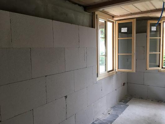 Innenwand mit weissen Daemm- und Bauplatten im Neubau.