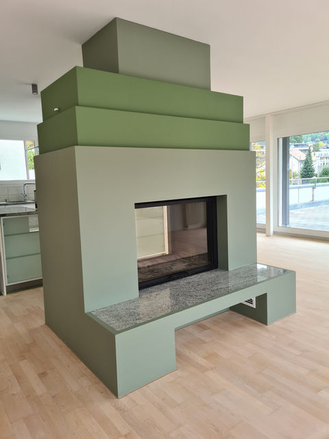 Moderner Kamin mit grün gestrichener Umfassung.