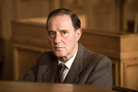 Ein ernst blickender Mann im Anzug bei Film Mittwoch.