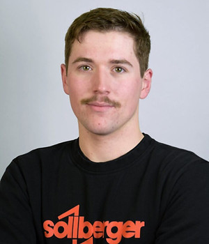 Teammitglied mit Schnurrbart und Sollberger-Sweatshirt