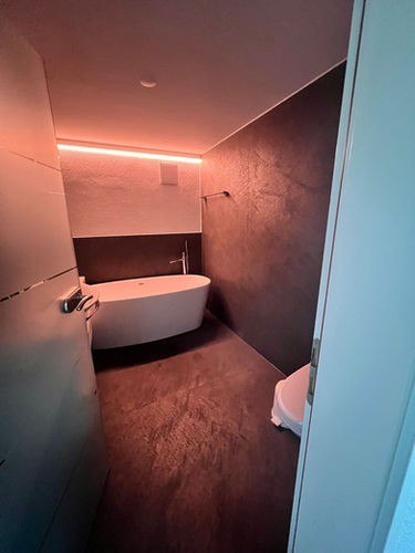 Elegantes Bad mit freistehender Wanne, Natursteinwänden.