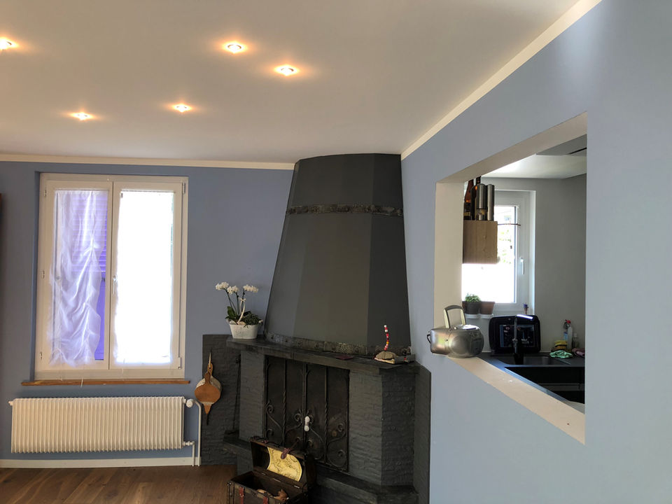 Wohnzimmer mit Kaminofen, Holzlager und integrierter Sitzbank.