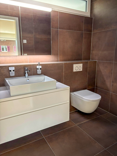 Modernes Badezimmer mit weißem Waschtisch und Wand-WC.