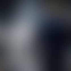 Operador en una planta de manufactura, visto de espaldas, sostiene una máscara de lobo; imagen inspirada en los therians para hablar de identidad y pertenencia.