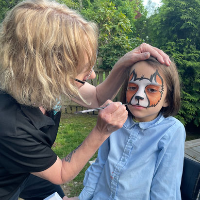face artist paints a cat on a young girl in Southport CT