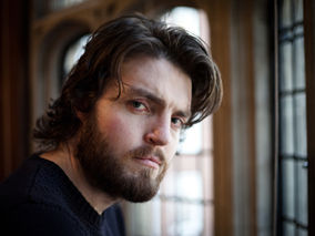 Tom Burke Cast as Cormoran Strike in Major BBC Event Drama Adaptations of The Galbriath Novels