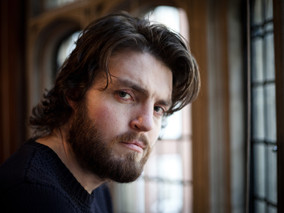 Tom Burke Cast as Cormoran Strike in Major BBC Event Drama Adaptations of The Galbriath Novels