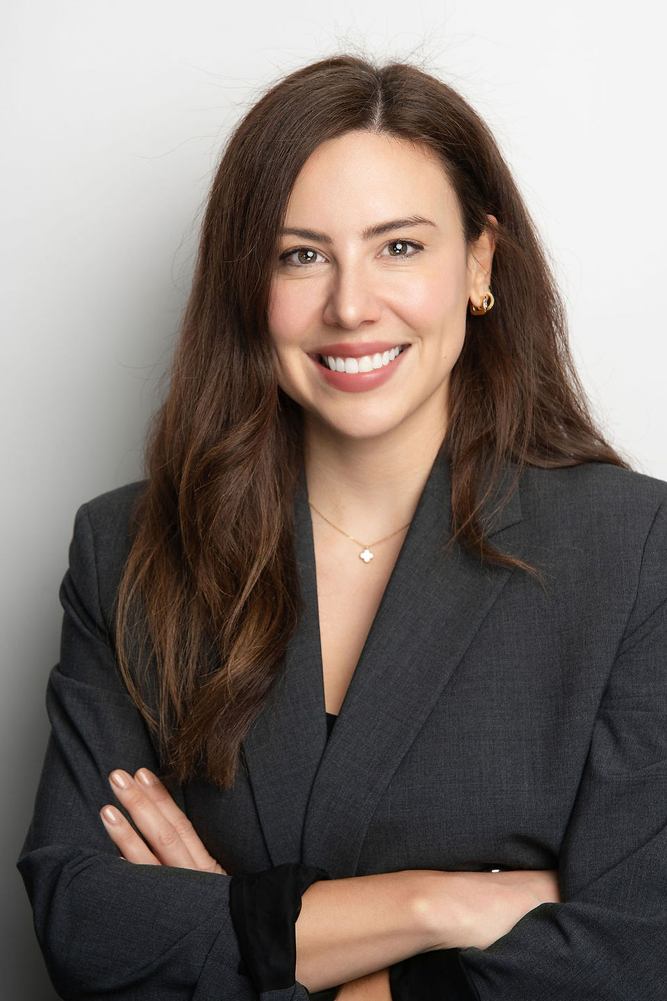 A person in a suit smiling with arms crossed  during Amsterdam headshot photoshoot.