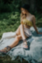 A woman sitting on a blanket on the grass - Coordinating Photo and Video Shoots for Fashion Brands