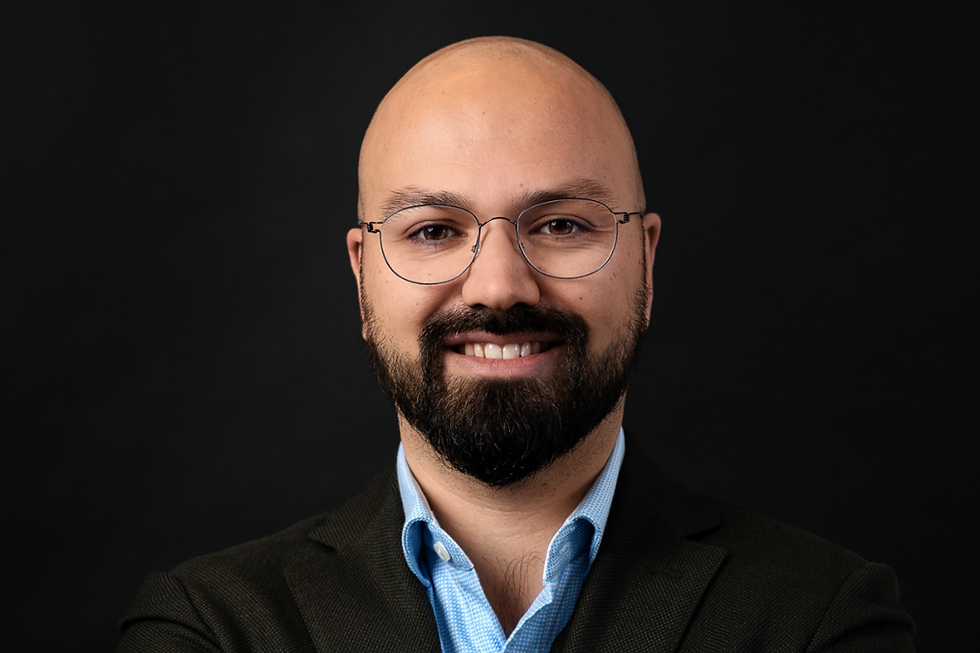 A portrait photo of a smiling man with glasses in headshots shoot