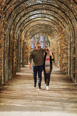 Couple walking under arches – engagement photographer capturing romantic moments in Amsterdam