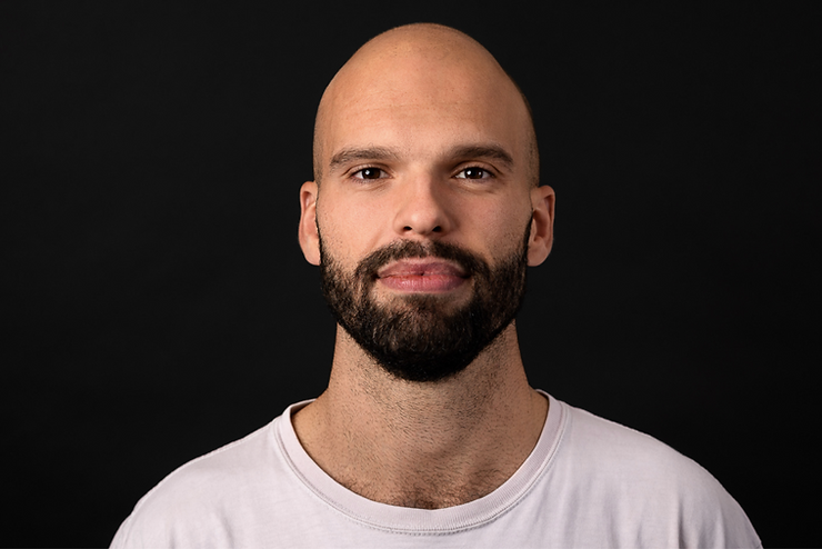 A man with beard on black background headshot photo