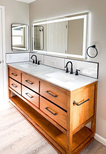 Light gray LVP flooring complements mango wood vanity and marble top in Worley bathroom remodel.