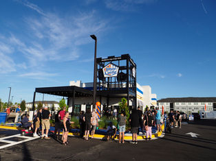 Crowd gathers outside White Castle under a blue sky, with a balloon column and the sign Desideres Ego Ergo Sum