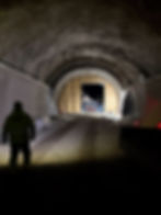 Arbeider pågår i snødekt tunnel med anleggsutstyr.