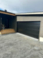 Moderne husprosjekt med svart garasjeport