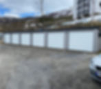 Moderne garasjerekke med hvite porter, et av våre prosjekter.