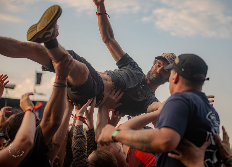 Spectateur porté par la foule lors d’un concert rock, ambiance énergique et participation du public