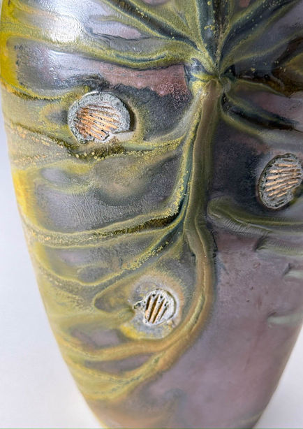 Zoomed in vase with green textured rivers and shell markings