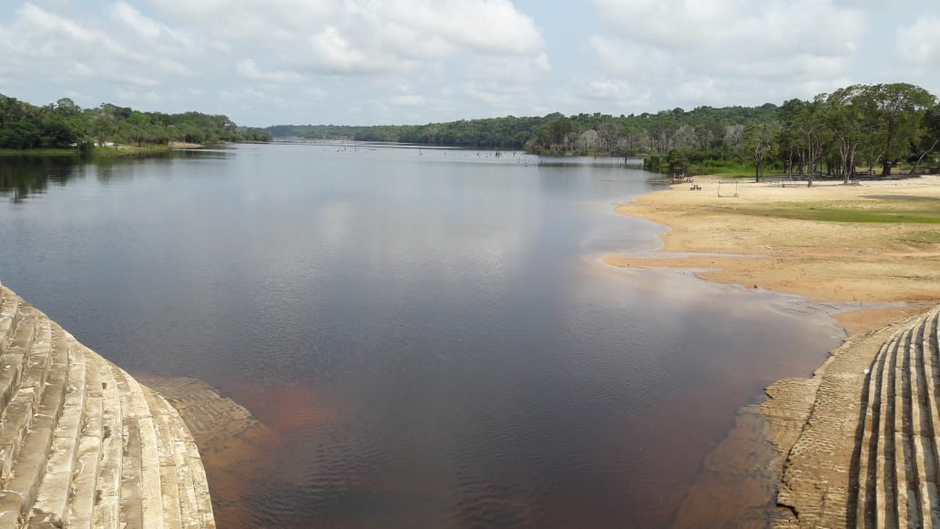 Visão do Rio Miriti a montante da ponte da rodovia Manoel Urbano (AM-070), em período vazante, com destaque para o represamento da água devido ao ‘estrangulamento’ do canal fluvial devido a obra de engenharia 