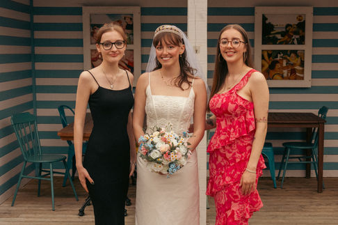 a bride and her two bridesmaids pose for a photo
