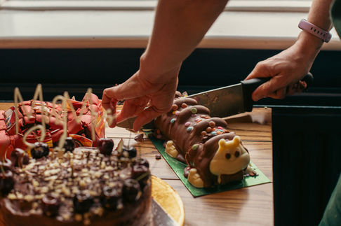 a person is cutting a chocolate caterpillar cake