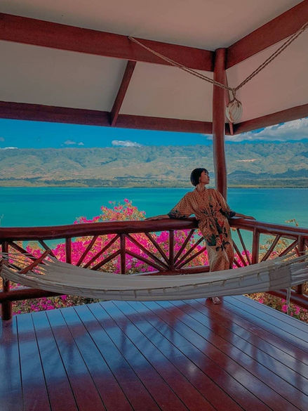 Woman at her hotel room balcony with a hammock. 