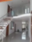 Vista general de pasamanos perimetral de acero y vidrio adaptado a un diseño de entrepiso curvo con estética vanguardista.