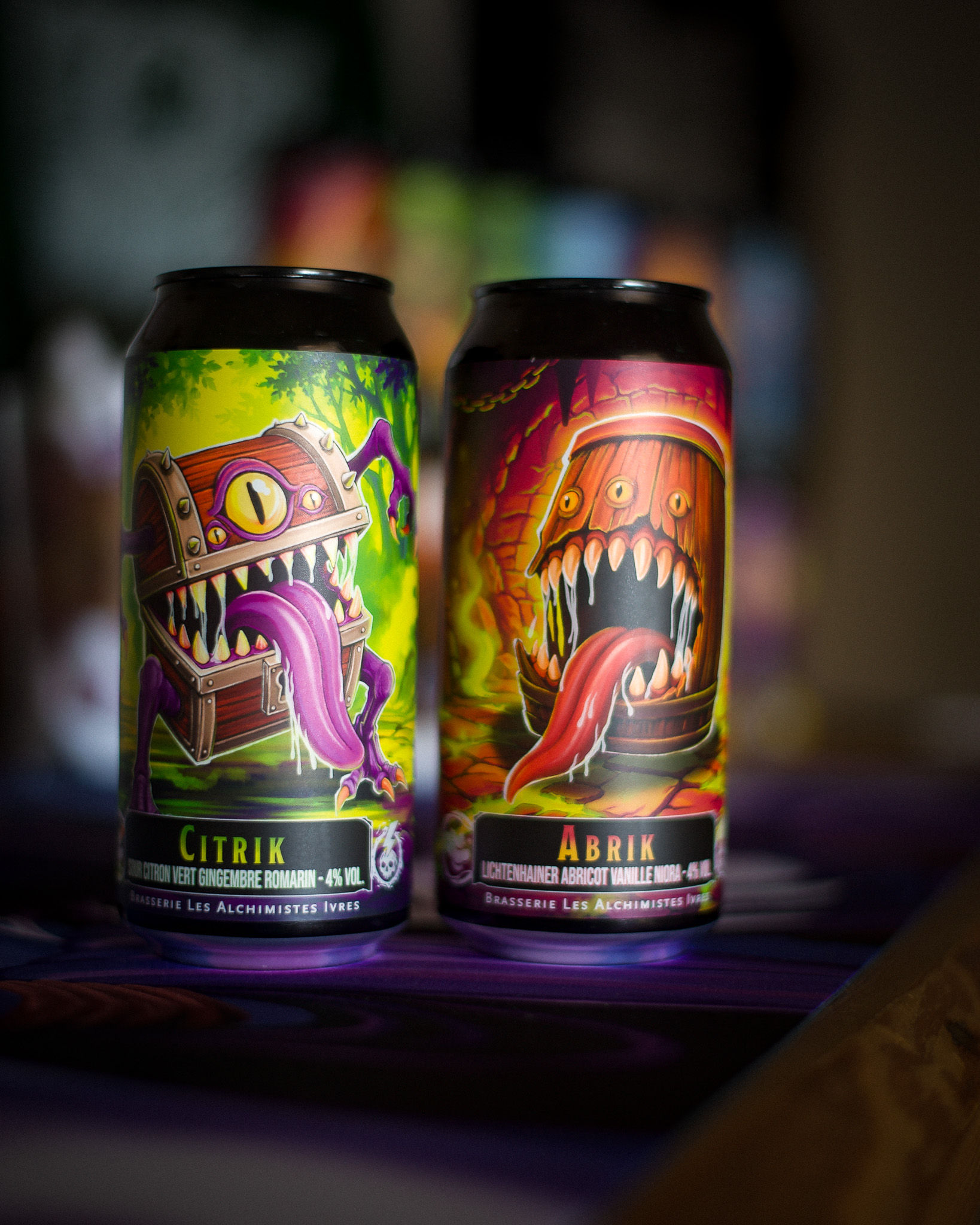 Canettes de bières craft de la série Replik des Alchimistes Ivres, avec Citrik Sour citron vert, gingembre et romarin, et Abrik Lichtenhainer à l’abricot, vanille et niora, aux illustrations fantasy.