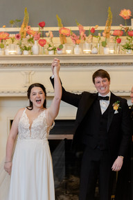Bride and Groom celebrating with their hands held high and together in unity in the Louise Marston Clonklin Room at The Madison Club, a Madison Wisconsin Wedding Venue