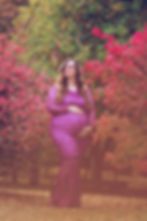 A pregnant mom holding a flower basket and wearing a beautiful maternity gown