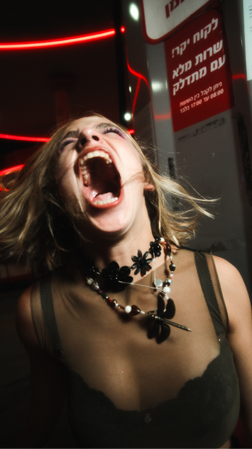Yali Nadel Screaming young woman, black necklace, dramatic background, Yali Nadel fashion model portfolio