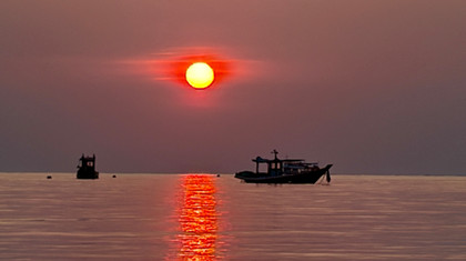 שקיעה מרהיבה בקו טאו עם סירה בים