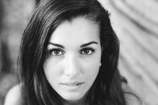 דיוקן בשחור לבן של אישה יפה עם מבט ישיר למצלמה.