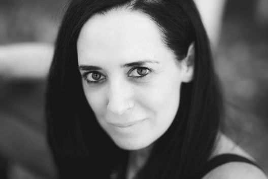 דיוקן בשחור לבן של אישה מחייכת עם מבט ישיר למצלמה.