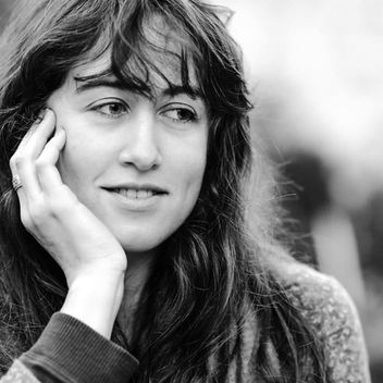 דיוקן בשחור לבן של אישה צעירה מחייכת, מסתכלת הצידה.