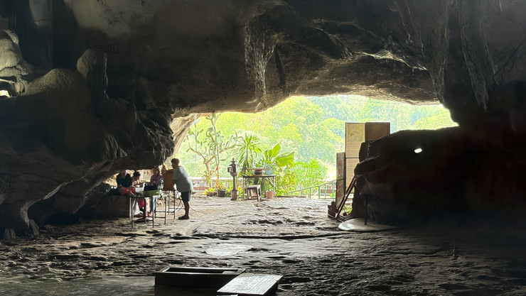 מבט מתוך מערה עם אנשים ונוף ירוק מחוץ לפתח