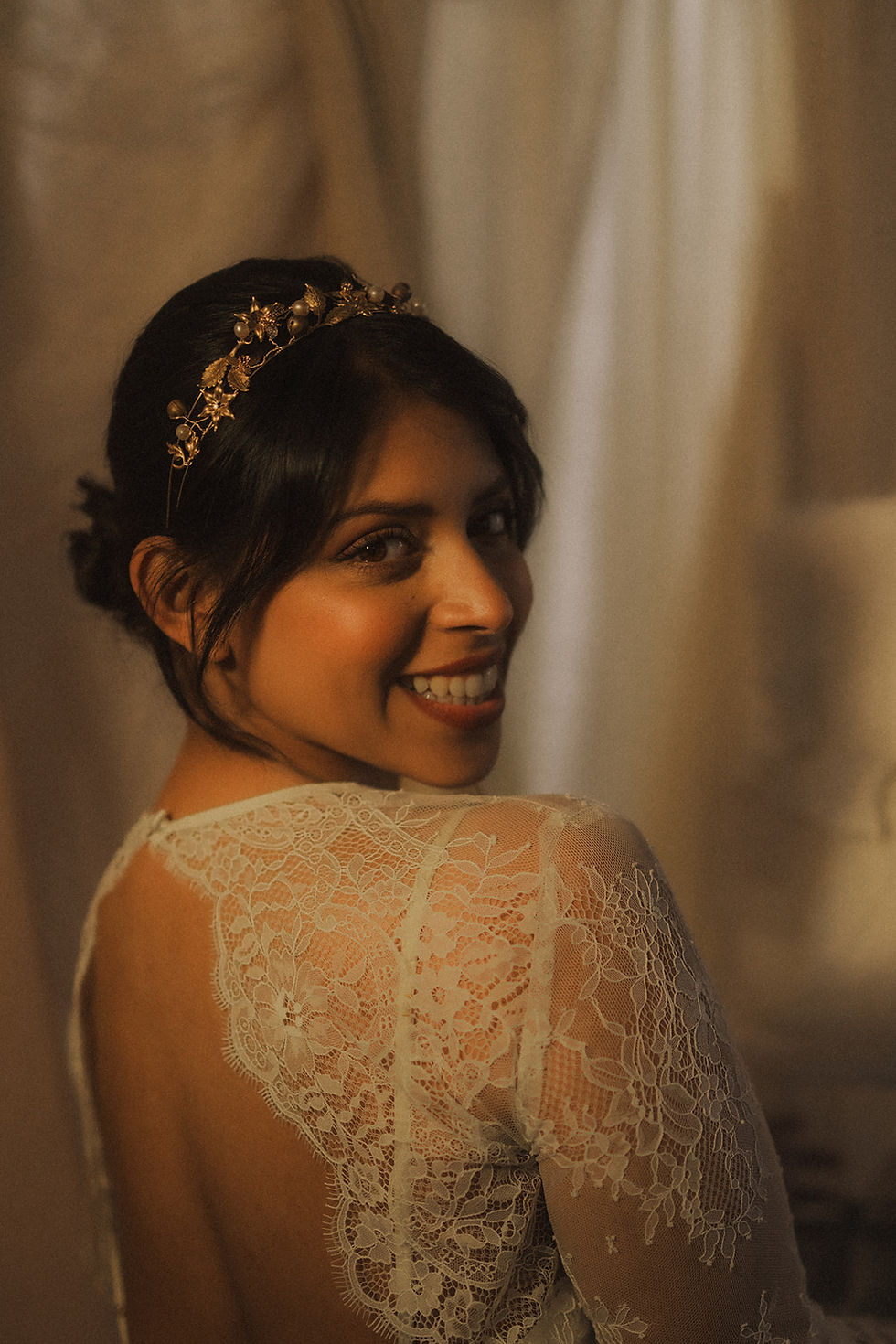 Thumbnail: Smiling woman wearing a white dress and the Gilded Vines Tiara, looking over shoulder with joy.