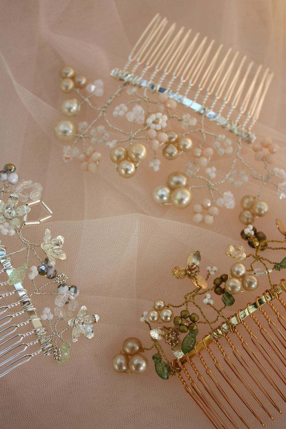 Thumbnail: Three decorative hair combs with pearls; Silver Garden Hair Comb rests on pink fabric