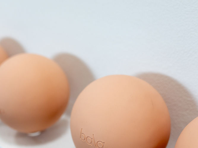 Neutral Bala balance balls resting on a clean white surface in natural light at Fire Sign Pilates studio