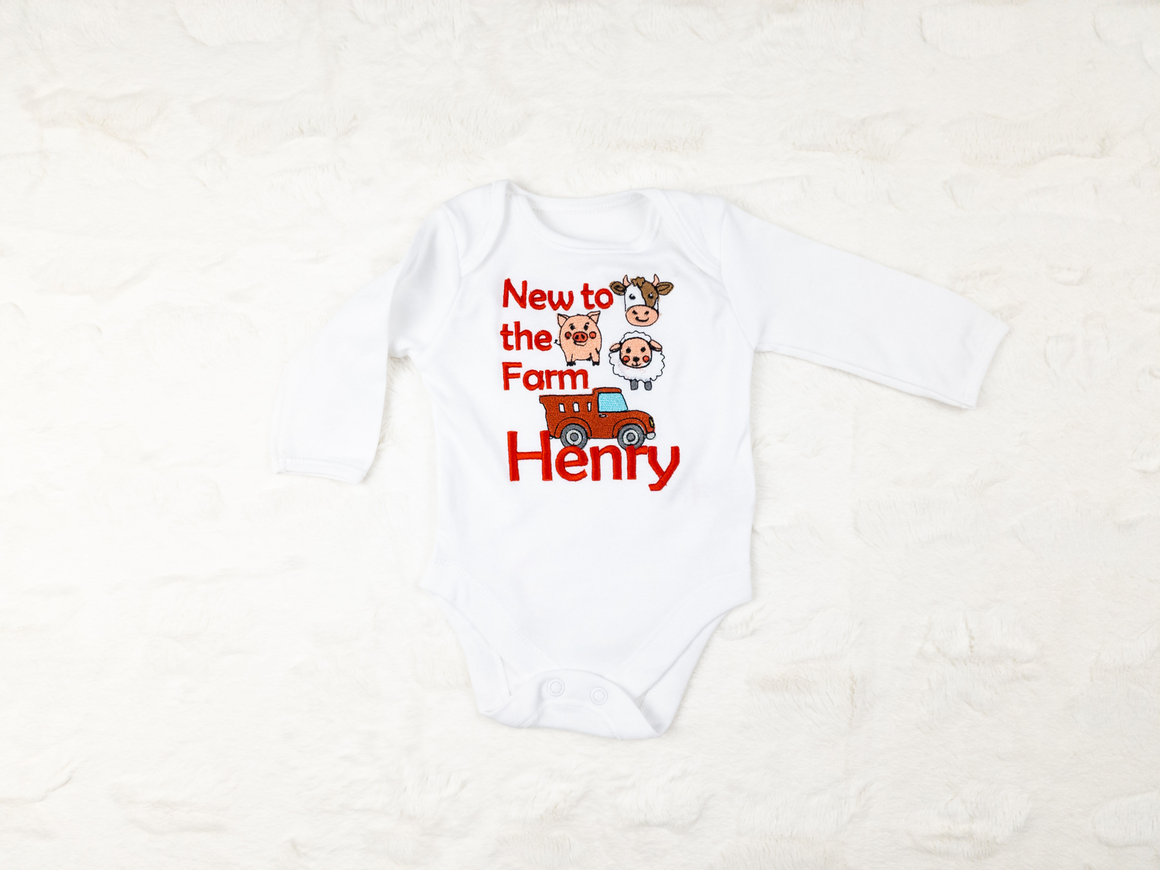 Bodijs ar izšuvumu fermas tematikā un bērna vārdu