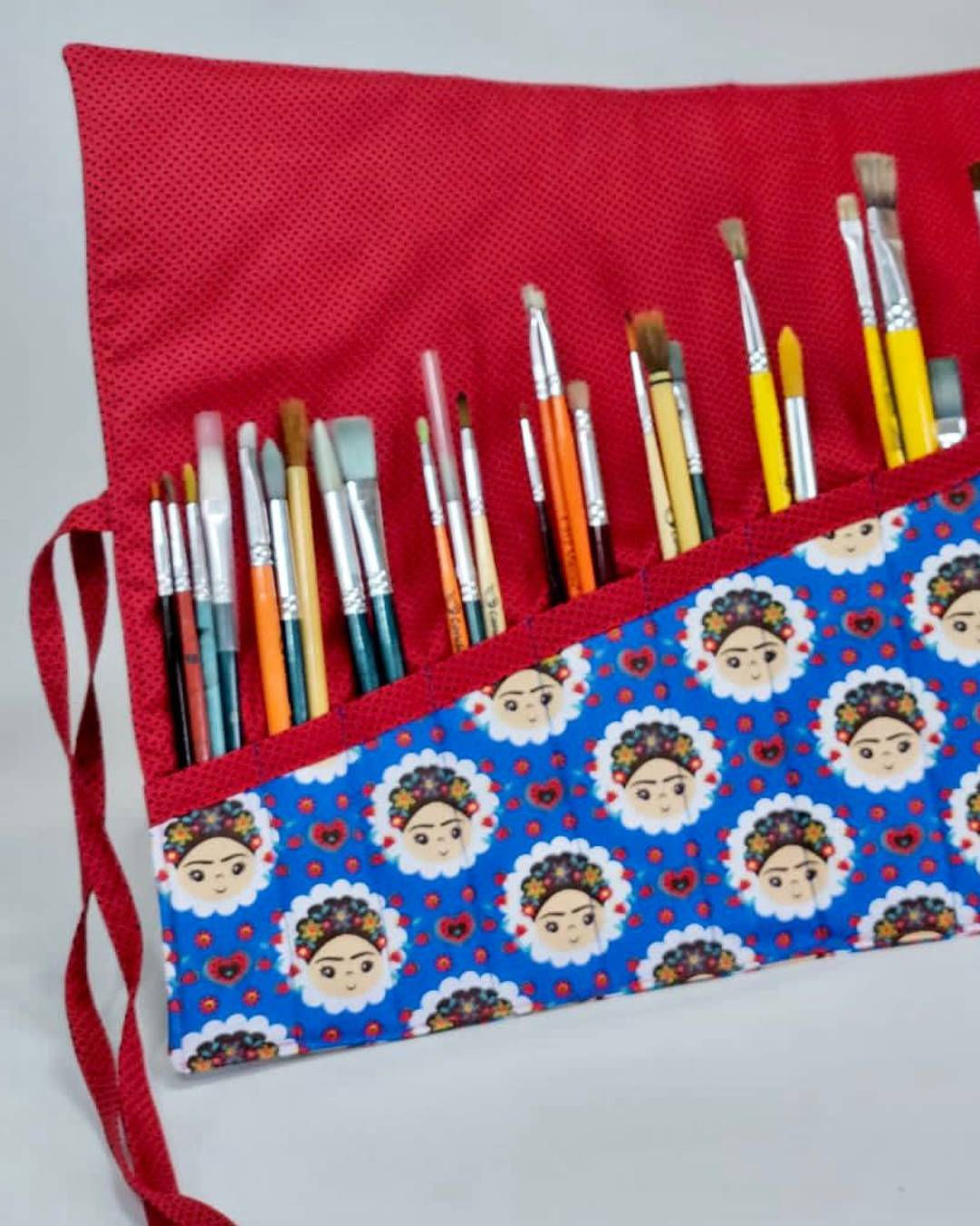Estojo artesanal enrolável para pincéis de pintura, ideal para organizar materiais artísticos.