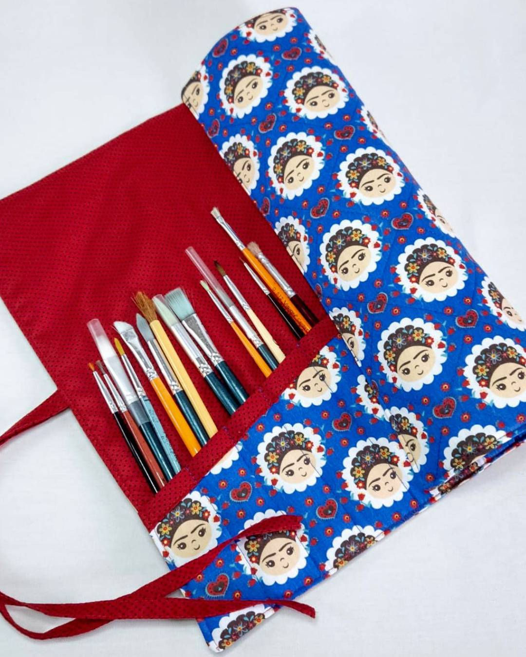 Estojo artesanal enrolável para pincéis de pintura, ideal para organizar materiais artísticos.